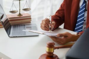 A male lawyer or notary is reviewing the statute of limitations, offering guidance to fellow male lawyers in a Revenue Office Law firm. They are consulting with a judge and a legal advisor also present in the office.