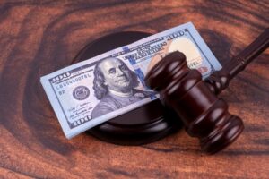 A judge's gavel and a dollar bill on a wooden table, symbolizing compensation in a bicycle accident