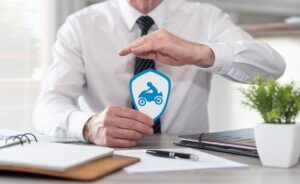 A man holds a blue motorcycle sticker, highlighting the significance of medical treatment after an accident