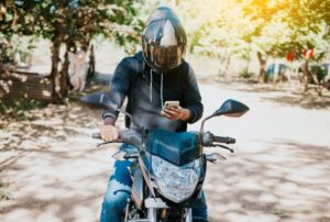 Man on motorbike texting while driving