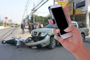 A person capturing photographs after a car and motorcycle accident