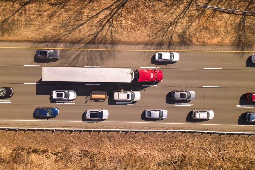 A truck between the traffic on the road