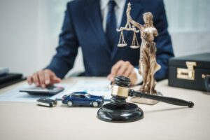 A male lawyer works at his desk in his office, focusing on a hit and run car accident case. 