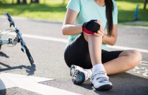 Bike injuries: A young woman cyclist fell off her road bike while cycling, resulting in a bicycle accident and an injured knee.