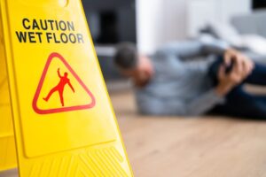 Yellow caution sign on a floor indicating a slip and fall hazard, emphasizing safety and accident prevention in public spaces.