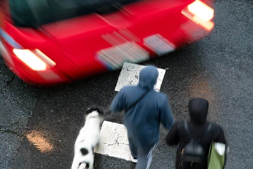 People pedestrian in dangerous situation in crosswalk in city street by vehicles at high speed