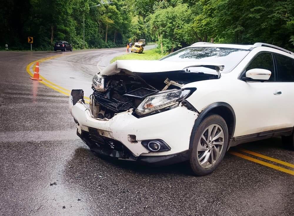 A white car had an accident on a curved road.