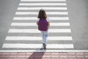 Kid runs across the crosswalk