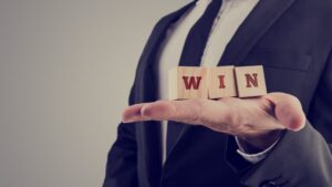 Lawyer holding wooden alphabet blocks reading - Win 