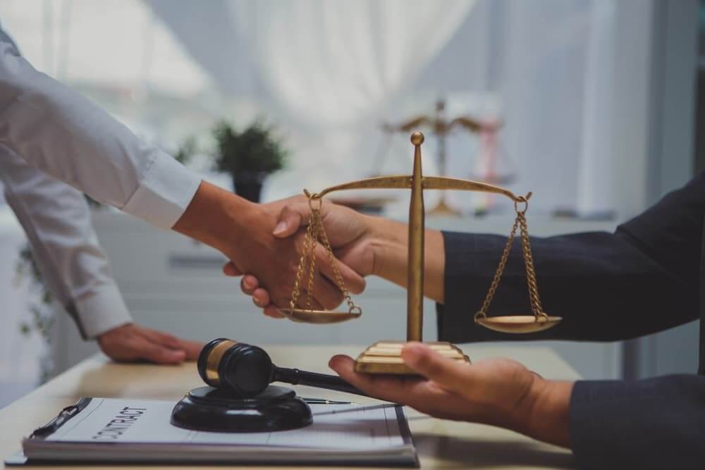 Personal injury lawyer hand shake with client