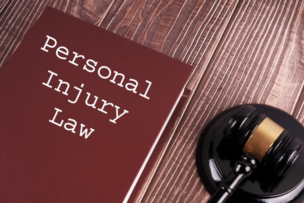 Personal Injury Law written on a book with judge gavel on wooden table background