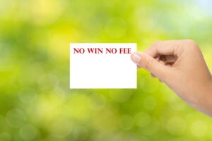 Hand holding a paper NO WIN NO FEE on green background