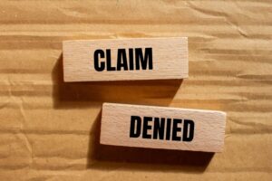 Claim Denied written on wooden pieces