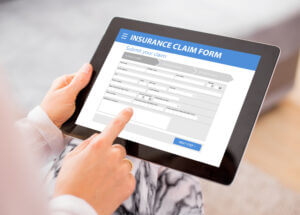 Person filling out a claim form to document income loss after an accident, essential for calculating lost earnings accurately. 