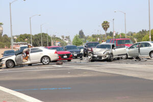 Multiple car collision at busy intersection with severe vehicle damage and traffic congestion.